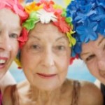 3 senior women friends wearing swimming caps