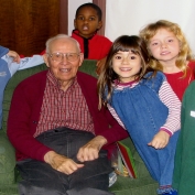 Children smiling with an older, male caregiver