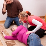 Adult children helping mother with Alzheimer's who is lying on floor