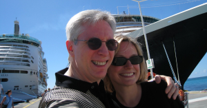 David Kramer and wife Tiffany in front of a cruise ship as he travels despite his Alzheimer's